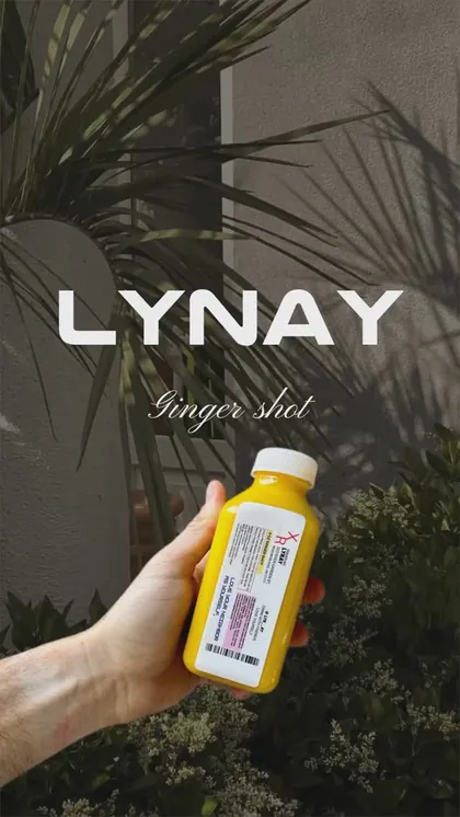 A LYNAY ginger shot bottle held in hand